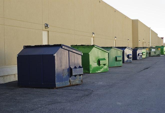 a team of workers hauls broken concrete in wheelbarrows to the dumpster in Brunswick, GA